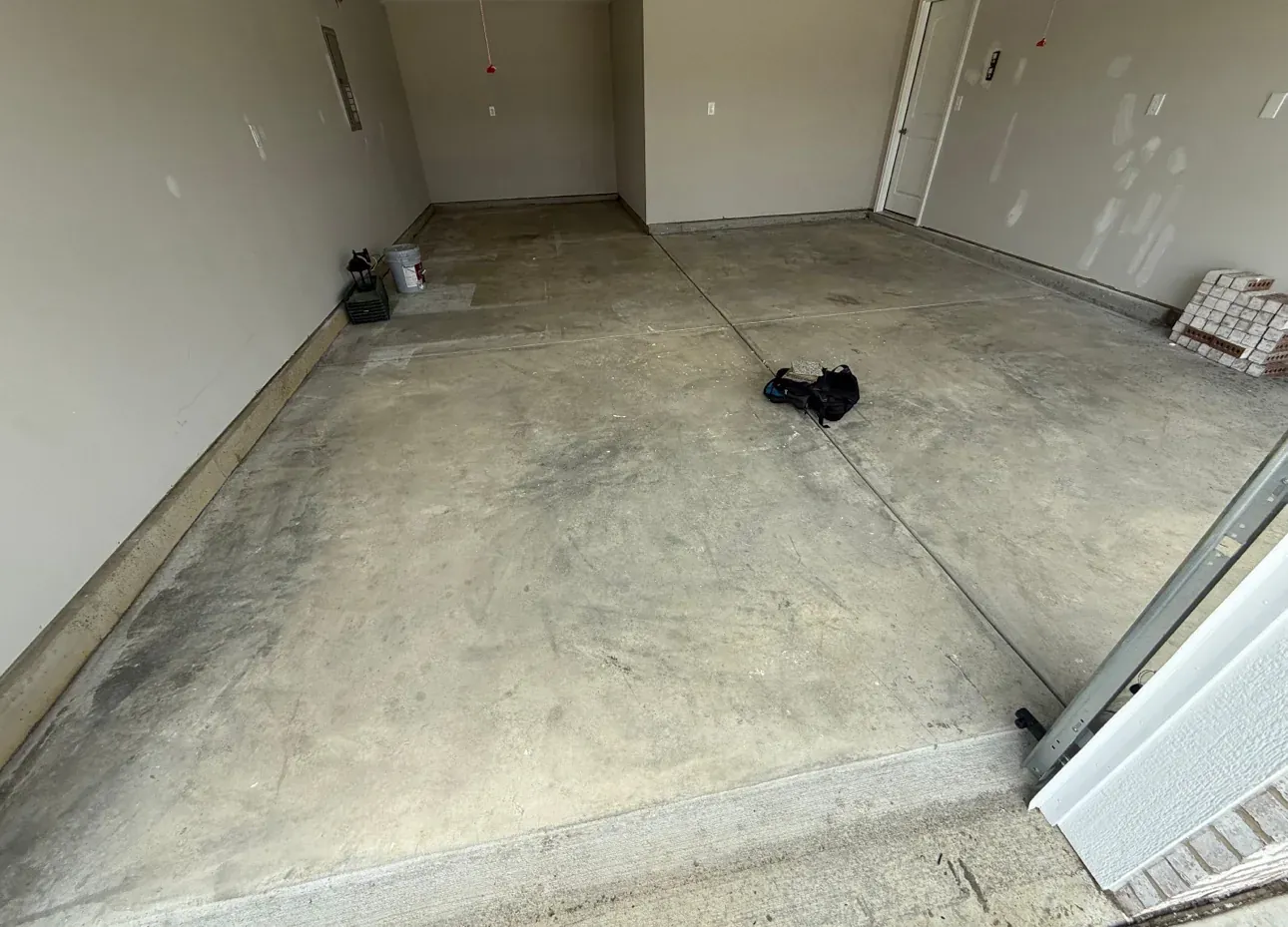 Cracked and stained garage concrete floor before polyaspartic coating in Indianapolis