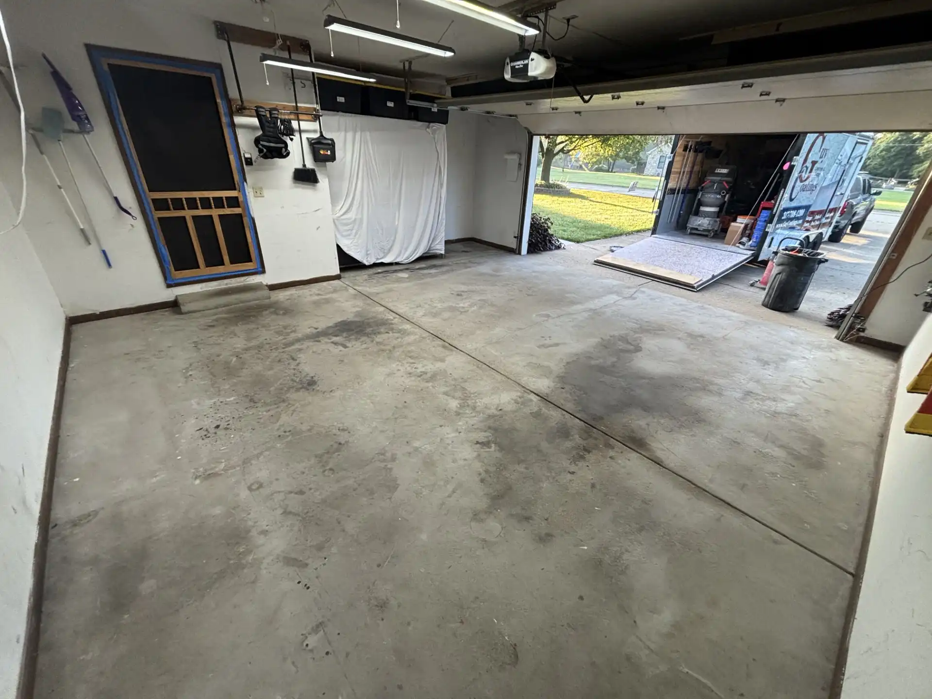 Oil-stained two-car garage concrete slab before Guy Coatings installation