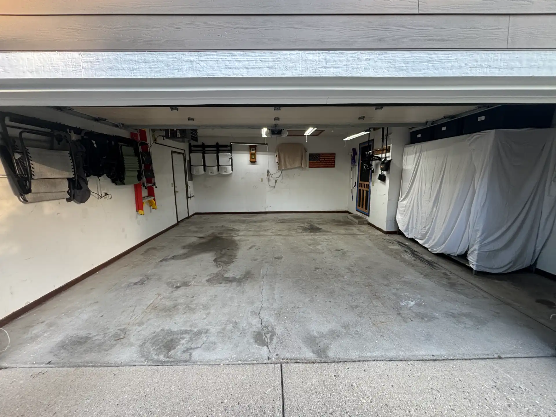 Stained and cracked bare concrete garage floor before coating